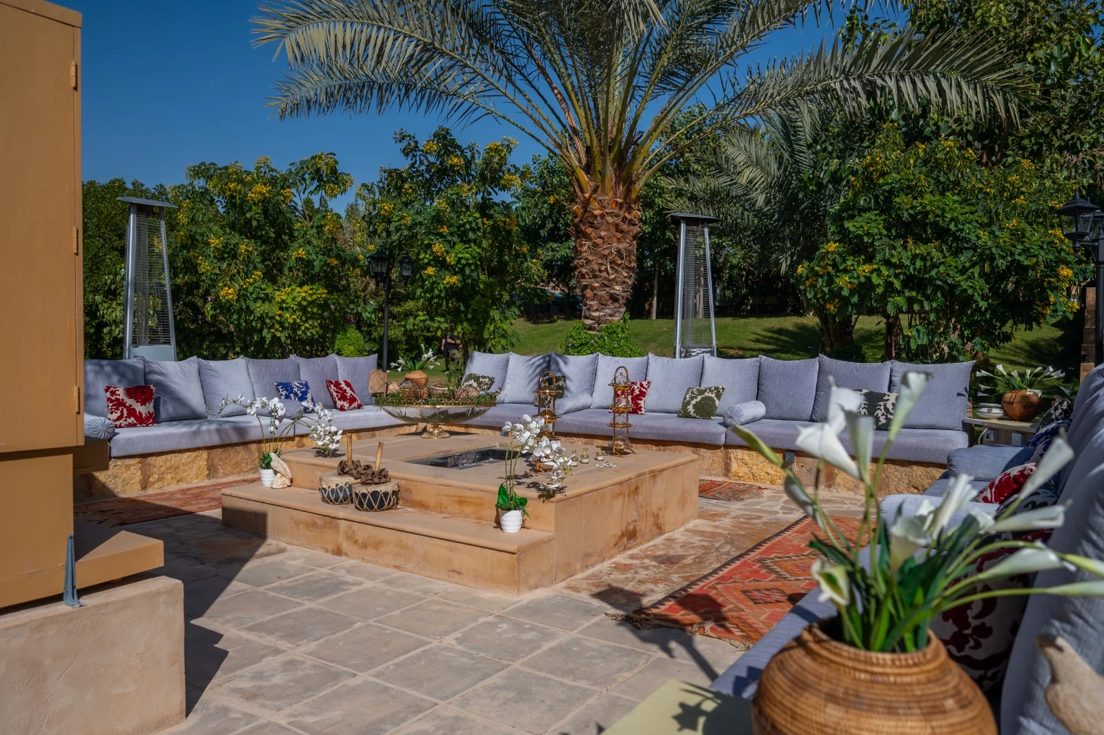Outdoor seating surrounded by palms and garden greenery